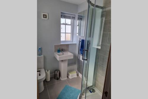 a small bathroom with a sink and a shower at 2 Bedroom Seafront Apartment in Felixstowe