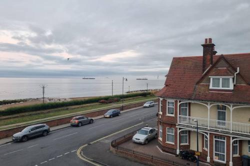 a road with cars parked on the side of a house at 2 Bedroom Seafront Apartment in Felixstowe
