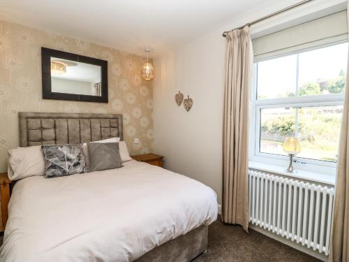 1 dormitorio con cama y ventana en Tree Tops, en Alston
