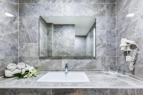 a bathroom with a sink and a mirror at Hotel Kriopigi in Kriopigi