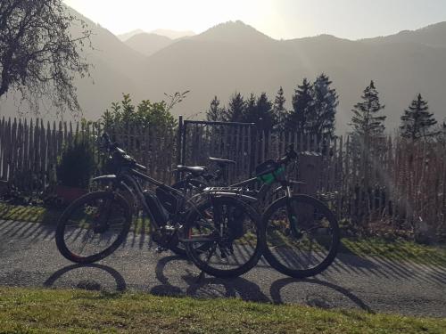 Dos bicicletas están estacionadas junto a una valla. en Inntalblick, en Nussdorf am Inn