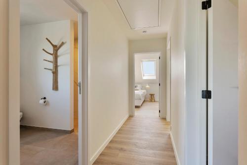 un pasillo que conduce a un baño con una pared blanca en Villa Boho, en Kortemark