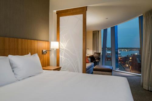 a hotel room with a bed and a large window at Hyatt Place Portland Downtown - Old Port Square in Portland