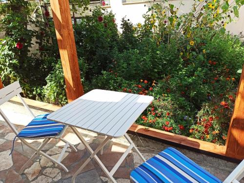 a white table and chairs in front of some flowers at Jermatun Guest House in Dilijan