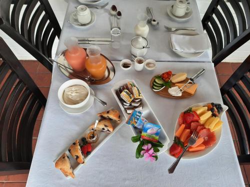 a table with plates of food and fruit on it at St. Lucia Wetlands Guest House in St Lucia