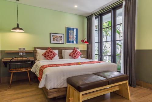 a bedroom with a bed and a desk and a window at Lamun at Canggu in Canggu