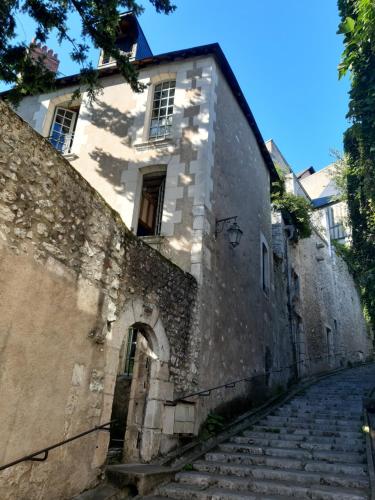 - un ancien bâtiment en pierre avec des escaliers devant dans l'établissement La suite St Laumer, à Blois