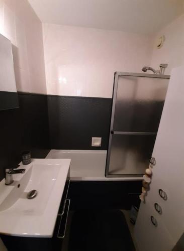 une salle de bain avec un lavabo blanc et un miroir dans l'établissement LE COSY aux pieds des pistes appartement avec balcon PLEIN CENTRE, à Orcières