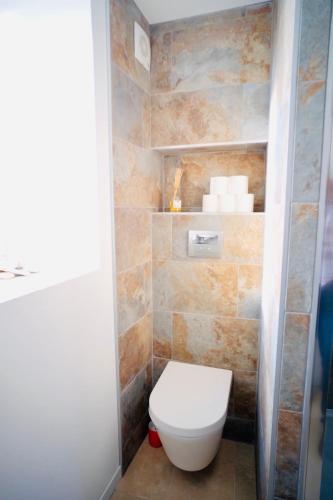 une salle de bain avec des toilettes blanches dans une chambre dans l'établissement le Perroquet Fringant, rue piétonne et quartier historique, à Caen