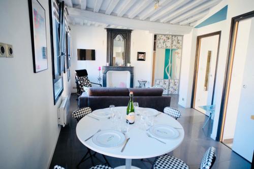 un soggiorno con tavolo e sedie bianchi di le Perroquet Fringant a Caen