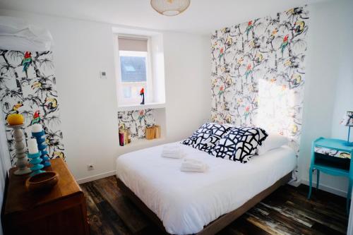 une chambre avec un lit avec un rideau et une fenêtre dans l'établissement le Perroquet Fringant, rue piétonne et quartier historique, à Caen