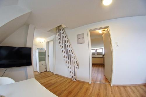 uma sala de estar com televisão e um quarto em MainQuartier em Norderney