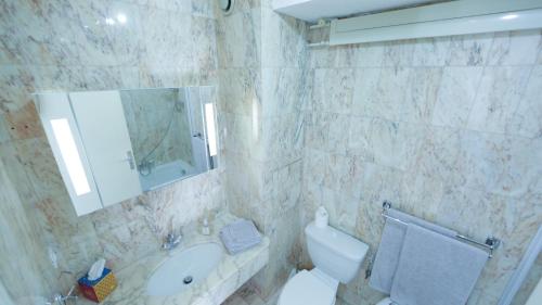 a bathroom with a sink and a toilet and a mirror at Studio parking fibre piscine Clim in Le Cannet