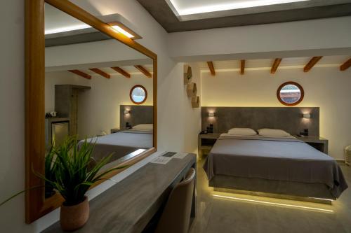Hotel Meteora في كالامباكا: غرفة نوم بسريرين ومرآة