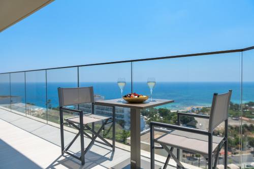 a table and chairs on a balcony with a view of the ocean at Amarande (Adults Only) in Ayia Napa