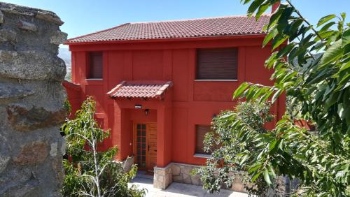 a red house with a red roof at Casa Rural Las Canales in Zapardiel de la Ribera