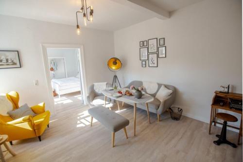 a living room with a table and a yellow chair at Apartment No4 in Stralsund
