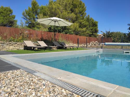 - une piscine avec un parasol, deux chaises et une table dans l'établissement Domaine d'Azéou, à Laure-Minervois