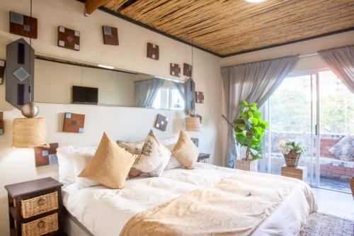a bedroom with a large white bed and a window at Bedrock Executive Studio Sea Facing in Cape Town