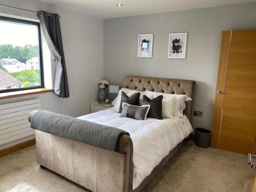 a bedroom with a large bed and a couch at Seren Las, Tenby in Tenby