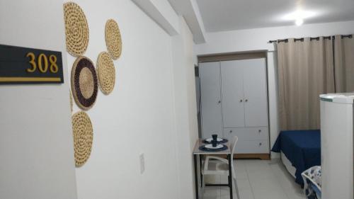 a room with a white wall with a table and a bed at Flat 308 in Teresina