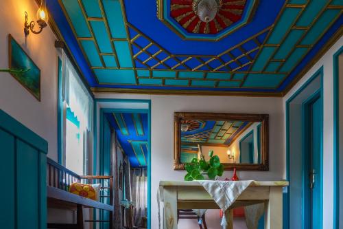 a room with a blue ceiling and a table at Vikos Hotel in Monodendri