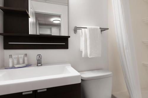 a bathroom with a sink and a toilet and a mirror at Howard Johnson by Wyndham Grande Prairie in Grande Prairie