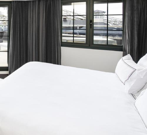 1 dormitorio con 2 camas y ventana en Meliá Sol y Nieve en Sierra Nevada