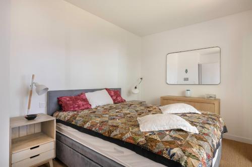 une chambre avec un lit et un miroir au mur dans l'établissement À 260m de la plage, bel appartement pour 4, à La Baule