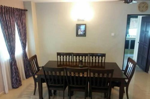a dining room with a wooden table and chairs at Aqua Blue Wave Port Dickson Home Villa in Port Dickson