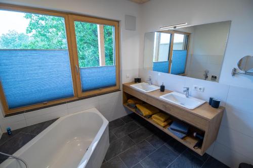 a bathroom with two sinks and a tub and a mirror at Der Bienenkorb in Blaichach