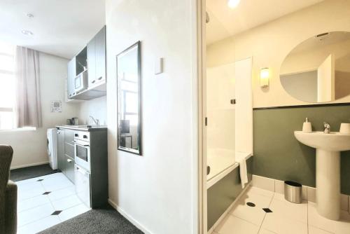 a small white bathroom with a sink and a sink at Bright & Cozy 1BR - Full Kitchen - Laundry & WiFi in Auckland