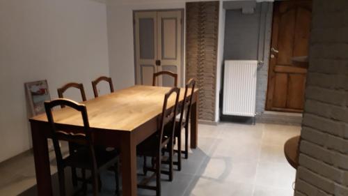 een eetkamer met een houten tafel en stoelen bij le sanglier in Bertogne