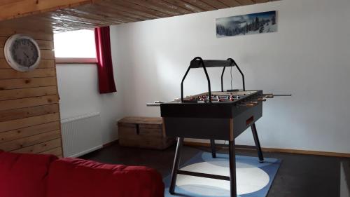 une table de jeu dans une pièce avec une horloge sur le mur dans l'établissement le sanglier, à Bertogne