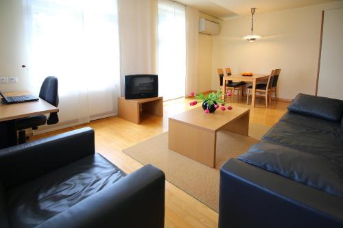 a living room with a couch and a table at Apartments Villa Boltez in Kranj