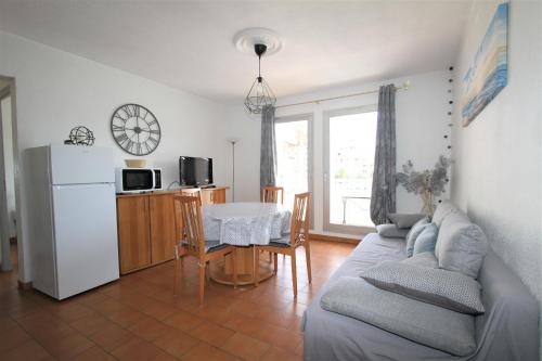 - un salon avec un canapé, une table et un réfrigérateur dans l'établissement QUAI12- Appartement T2 vue Marina, à Canet