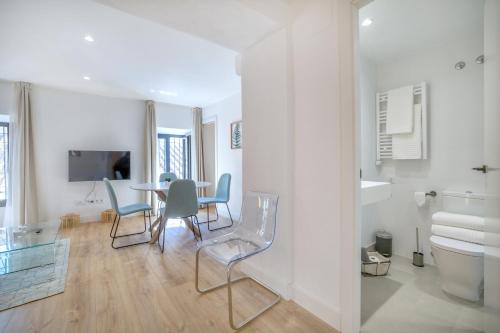 - un salon blanc avec une table et des chaises dans l'établissement Victoria Suites Apartments, à Cordoue