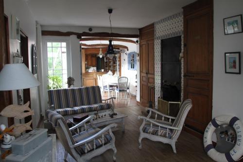 un salon avec un canapé, des chaises et une table dans l'établissement Maison favieres baie de Somme, à Favières