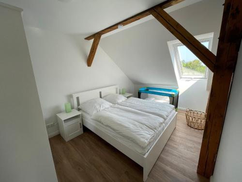 ein Schlafzimmer mit einem weißen Bett und einem Fenster in der Unterkunft Ferienvermietung Klakus - a60263 in Fehmarn