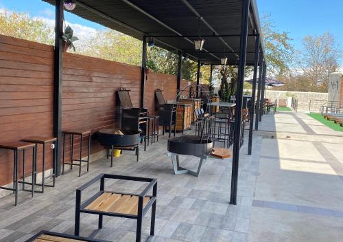 a covered patio with tables and chairs and a bench at Hotel Colonial Tafi del Valle by DOT Tradition in Tafí del Valle