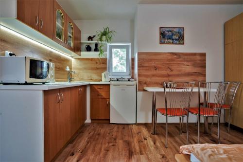 a kitchen with a table and chairs and a microwave at Apartmány Anna in Liptovský Michal
