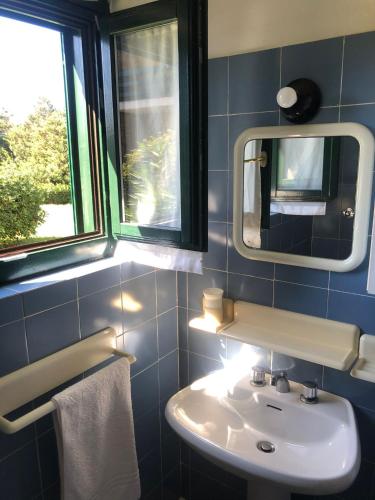 a bathroom with a sink and a mirror at NRH Stintino Beach Garden in Stintino