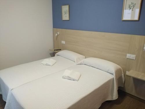 two beds in a hotel room with white sheets at LA VILLA DE ORGAZ in Orgaz
