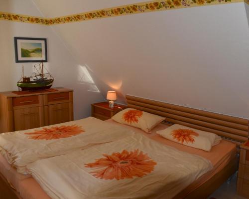 a bedroom with two beds with orange pillows at Ferien unterm Reetdach Whg 01 in Oevenum