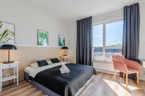 a bedroom with a bed and a large window at Grobla by Loft Apartments in Gdańsk