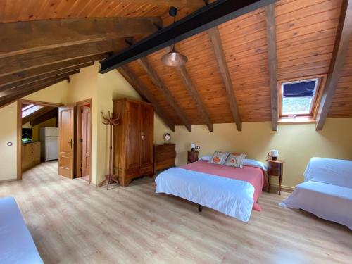 a bedroom with two beds and wooden ceilings at Casa Rural Era de Ferro in Erill la Vall