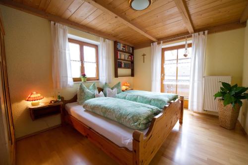 - une chambre avec un lit dans une pièce dotée de plafonds en bois dans l'établissement Ferienwohnung Mohnblume, à Burggen