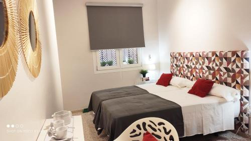een slaapkamer met een bed en een raam bij Sweet Home Alameda 2 in Sevilla