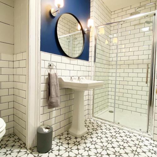 a white bathroom with a sink and a mirror at No. 1 Bridge Street in Westport