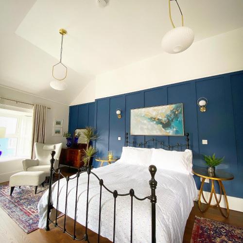 a bedroom with a bed and a blue wall at No. 1 Bridge Street in Westport